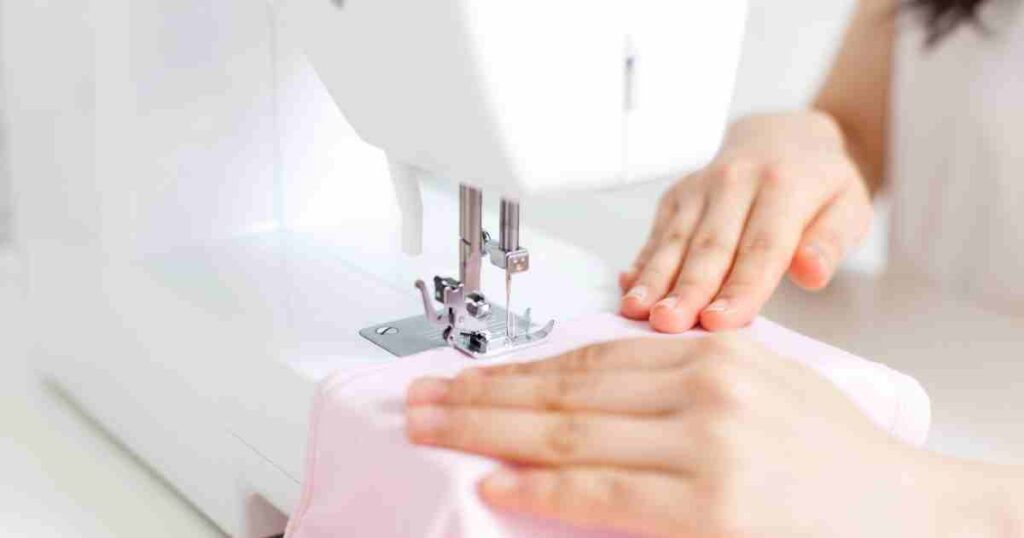 ミシンで薄いピンクの布を縫う